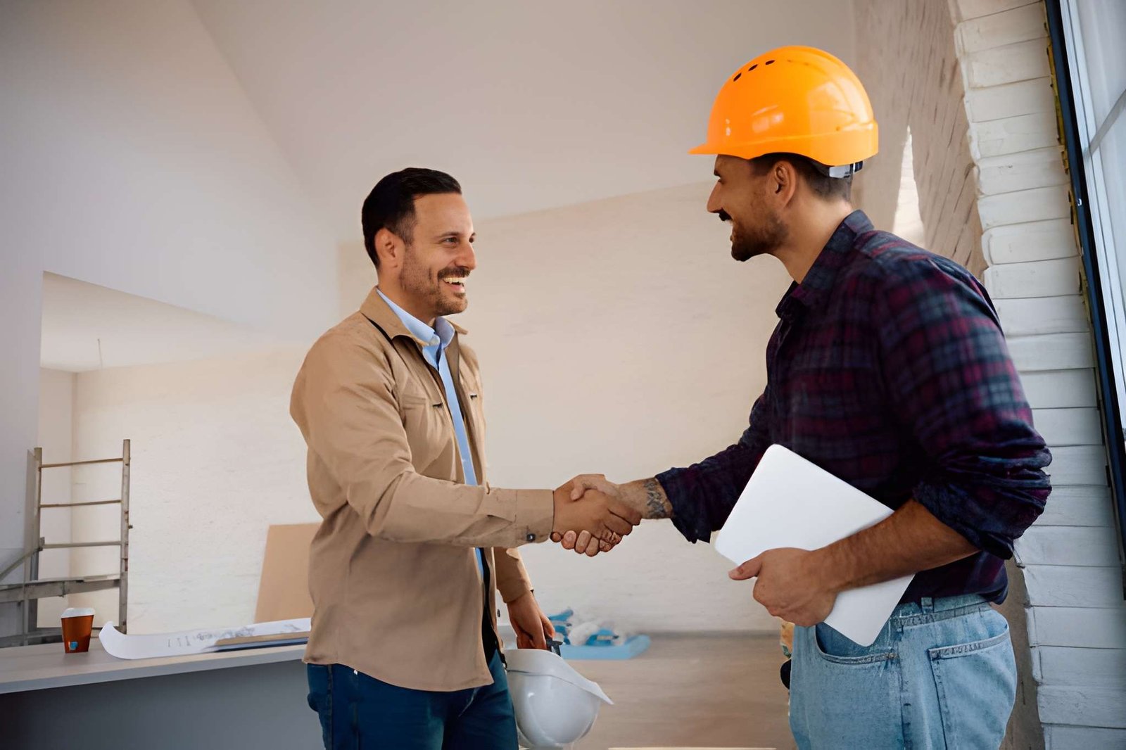 Homeowner and construction worker handshaking on site